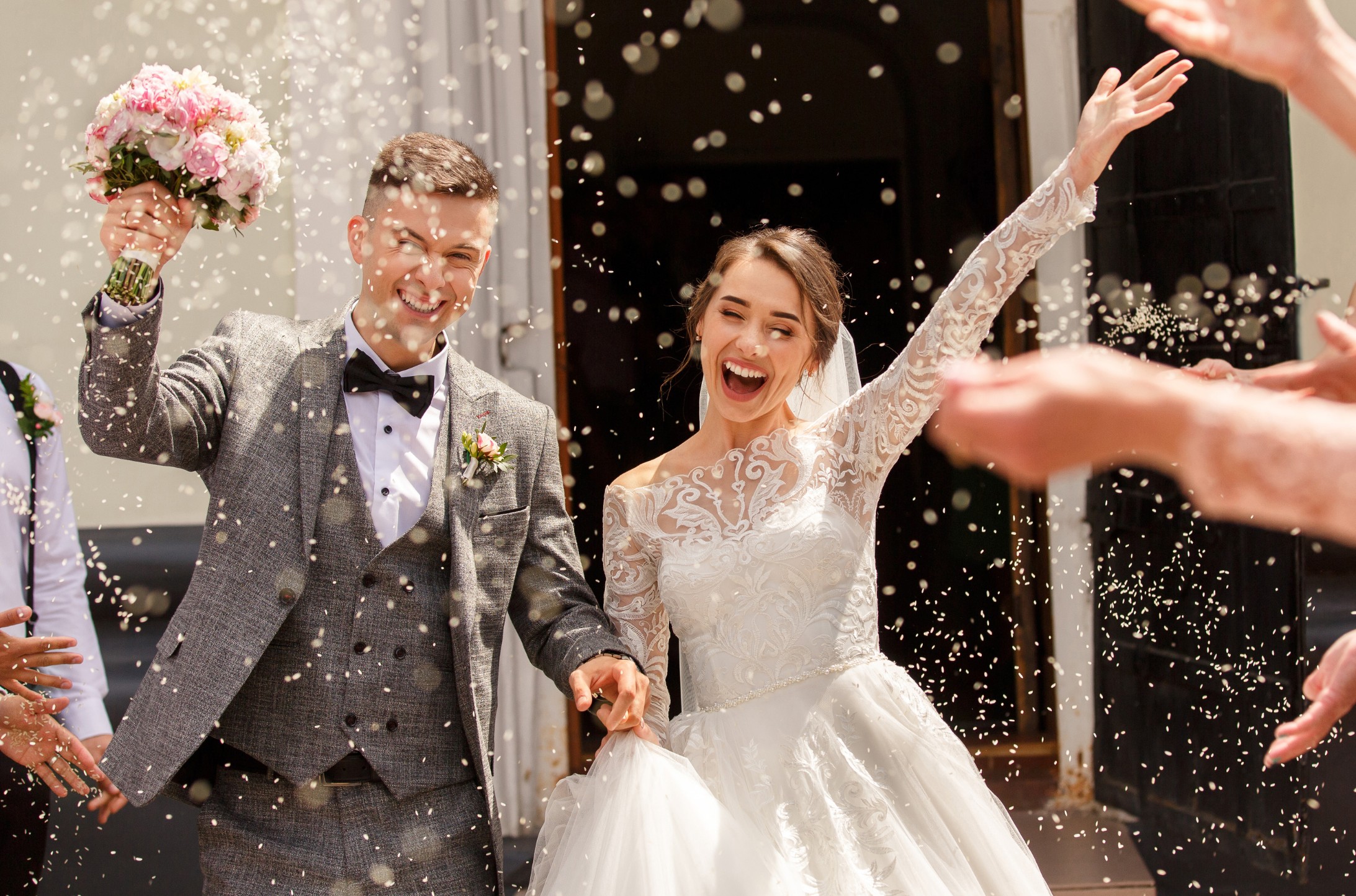 Invitados tirando confeti a los novios saliendo de la ceremonia