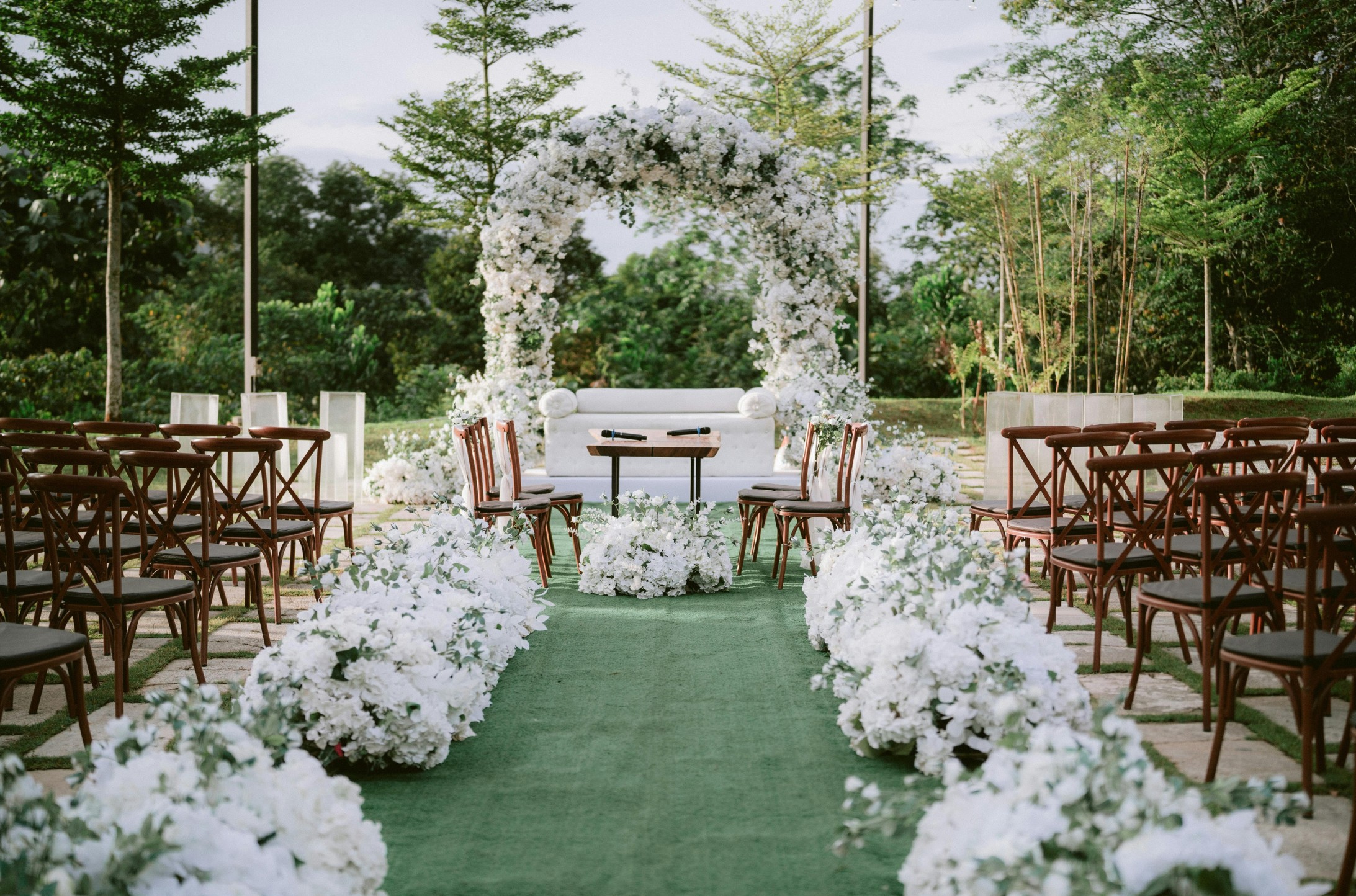 Ceremonia de casamiento al aire libre con arco floral blanco